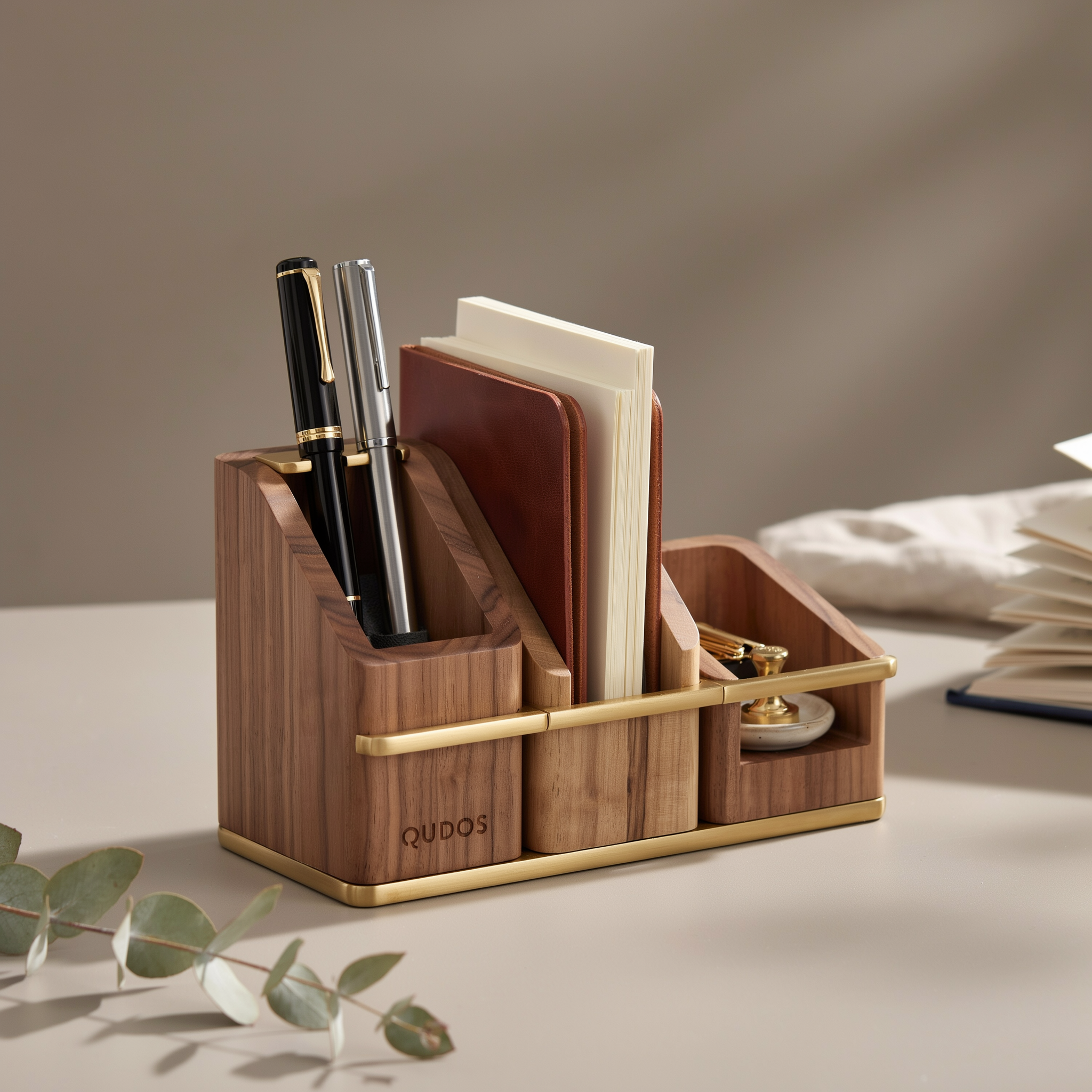 Qudos walnut desk organizer with brass accents holding pens and notebooks